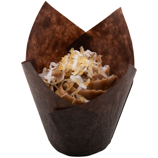 Cupcake in a brown wrapper topped with coconut shavings